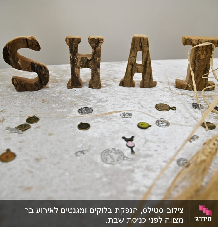 אותיות עץ על שולחן עם מטבעות וקישוטים